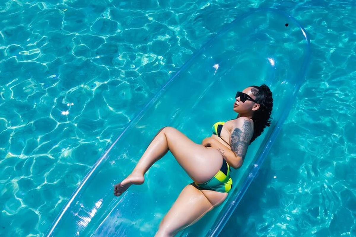 žena u bikiniju sjedi na splavi u bazenu