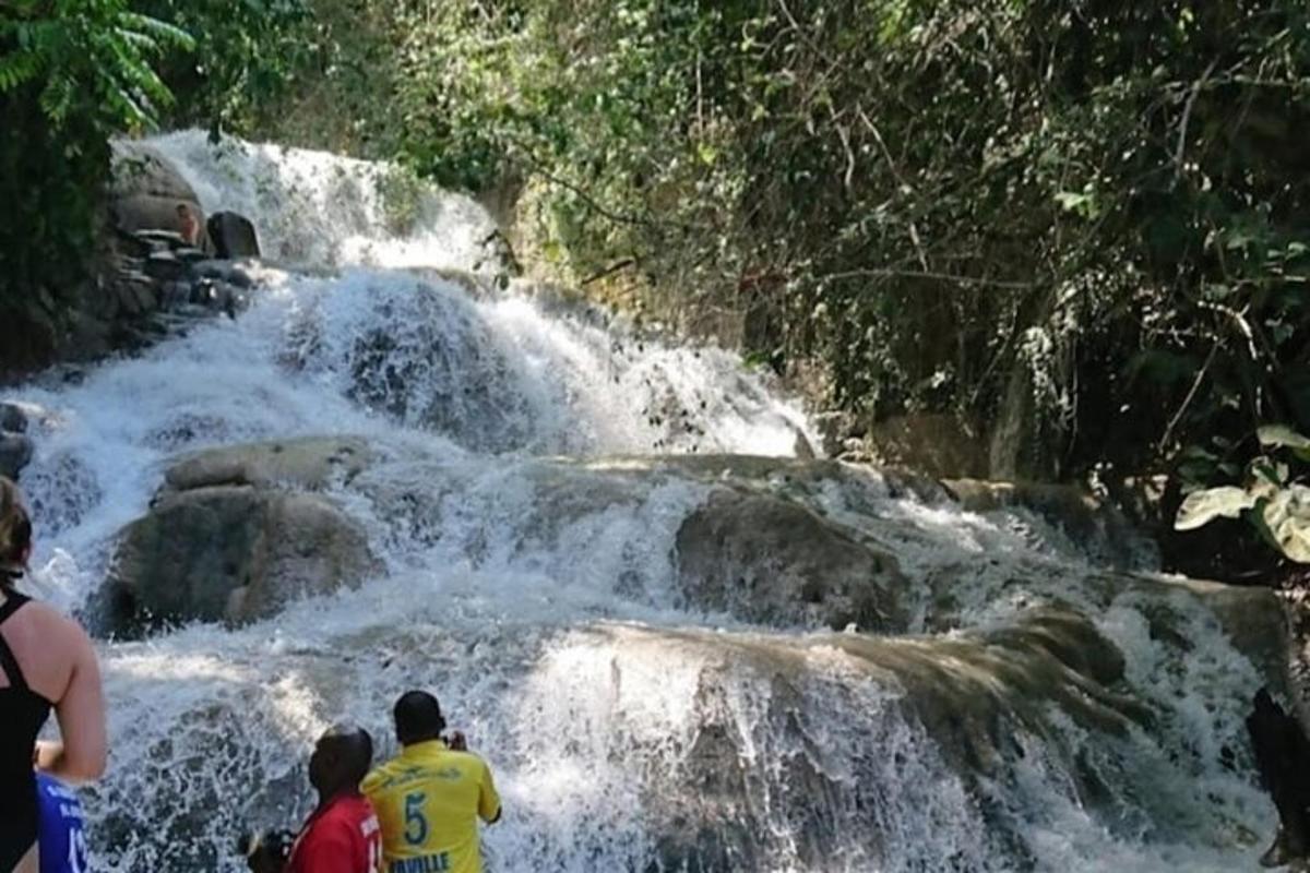 two people standing in front of a waterfall