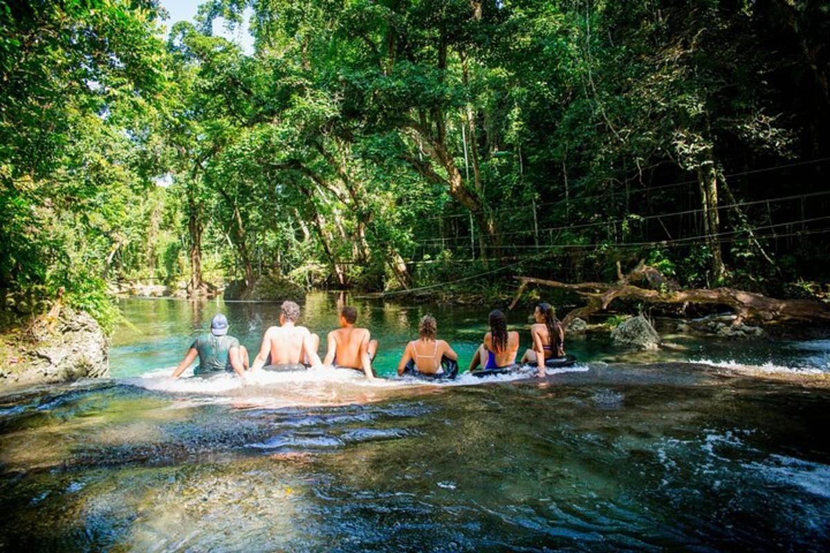 a group of people sitting in the water in a river