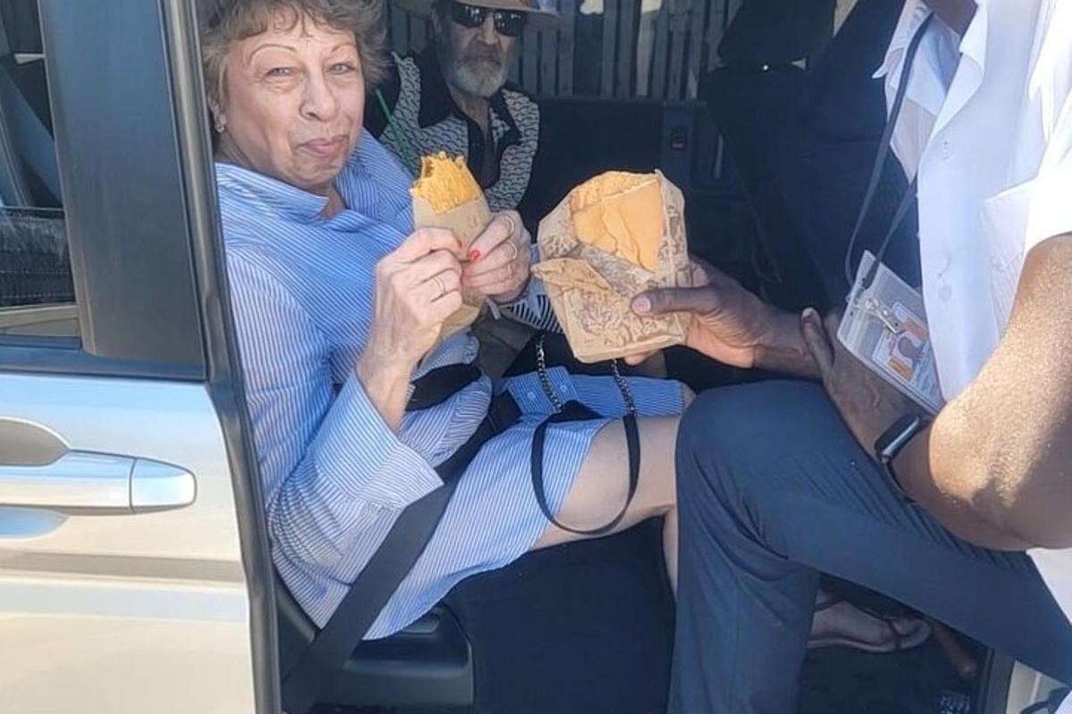 starší žena sedící v autobuse s jídlem v ruce