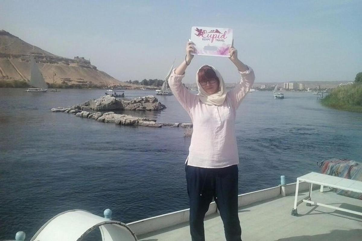 Una mujer parada en un bote sosteniendo un cartel