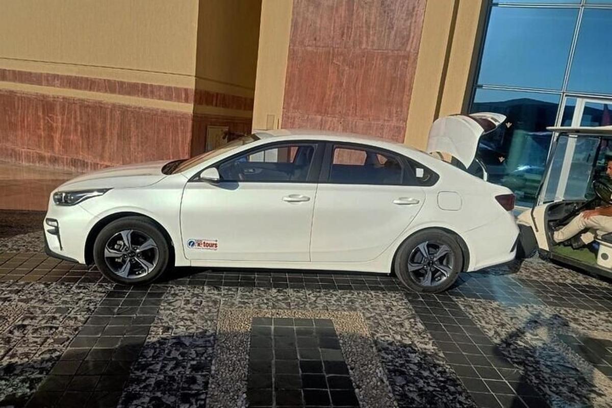 um carro branco estacionado em frente a um prédio