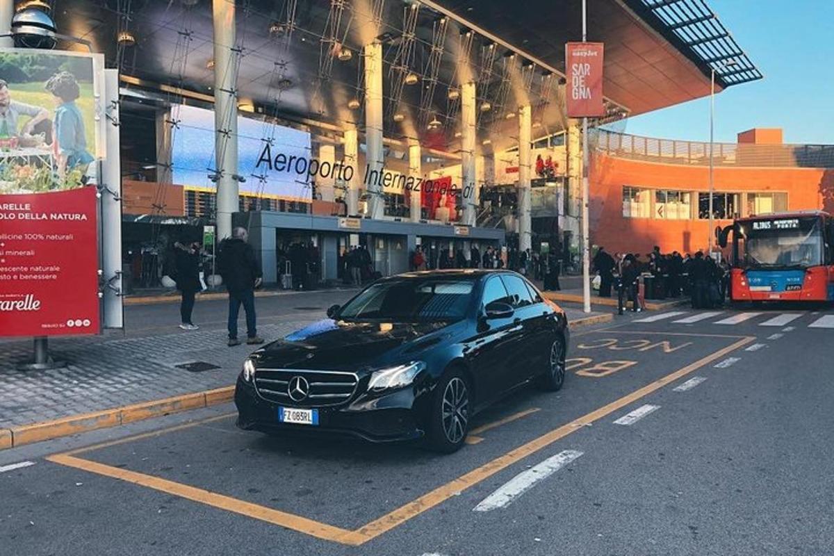 um carro preto estacionado em um estacionamento em frente a um prédio