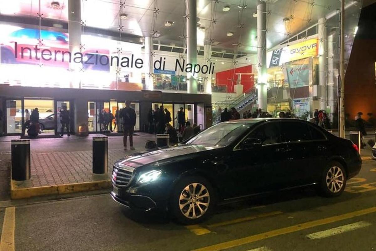um carro preto estacionado em frente a um prédio