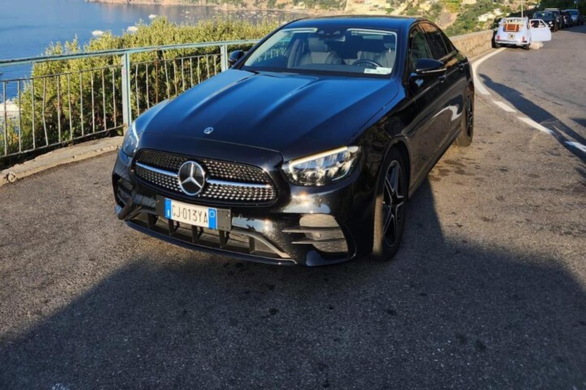 um carro preto estacionado na beira de uma estrada