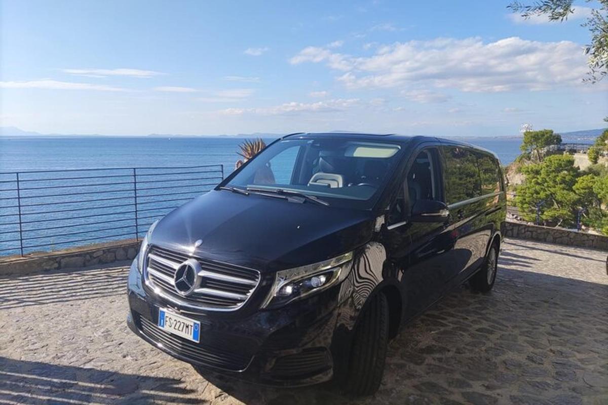 um SUV preto estacionado perto do oceano