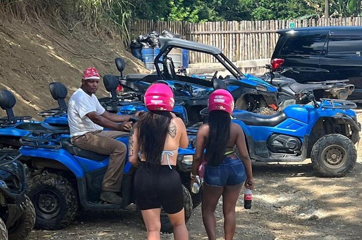um homem sentado em um quadriciclo azul com duas garotas