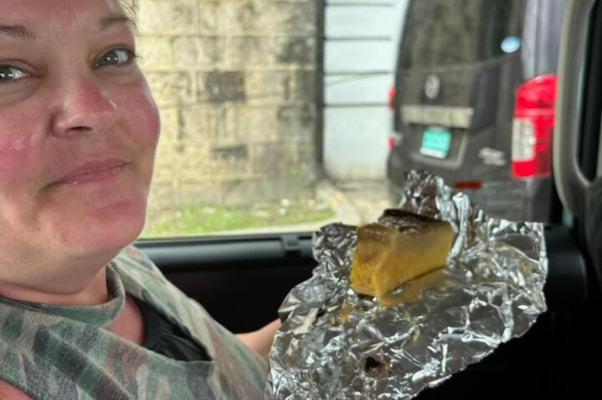seorang lelaki duduk di dalam kereta sambil memegang sekeping makanan