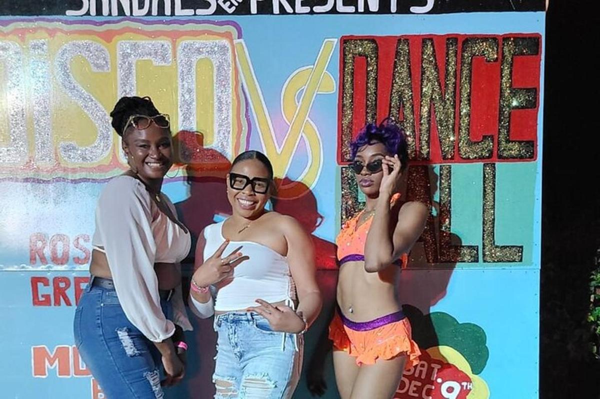 a group of three women standing in front of a sign