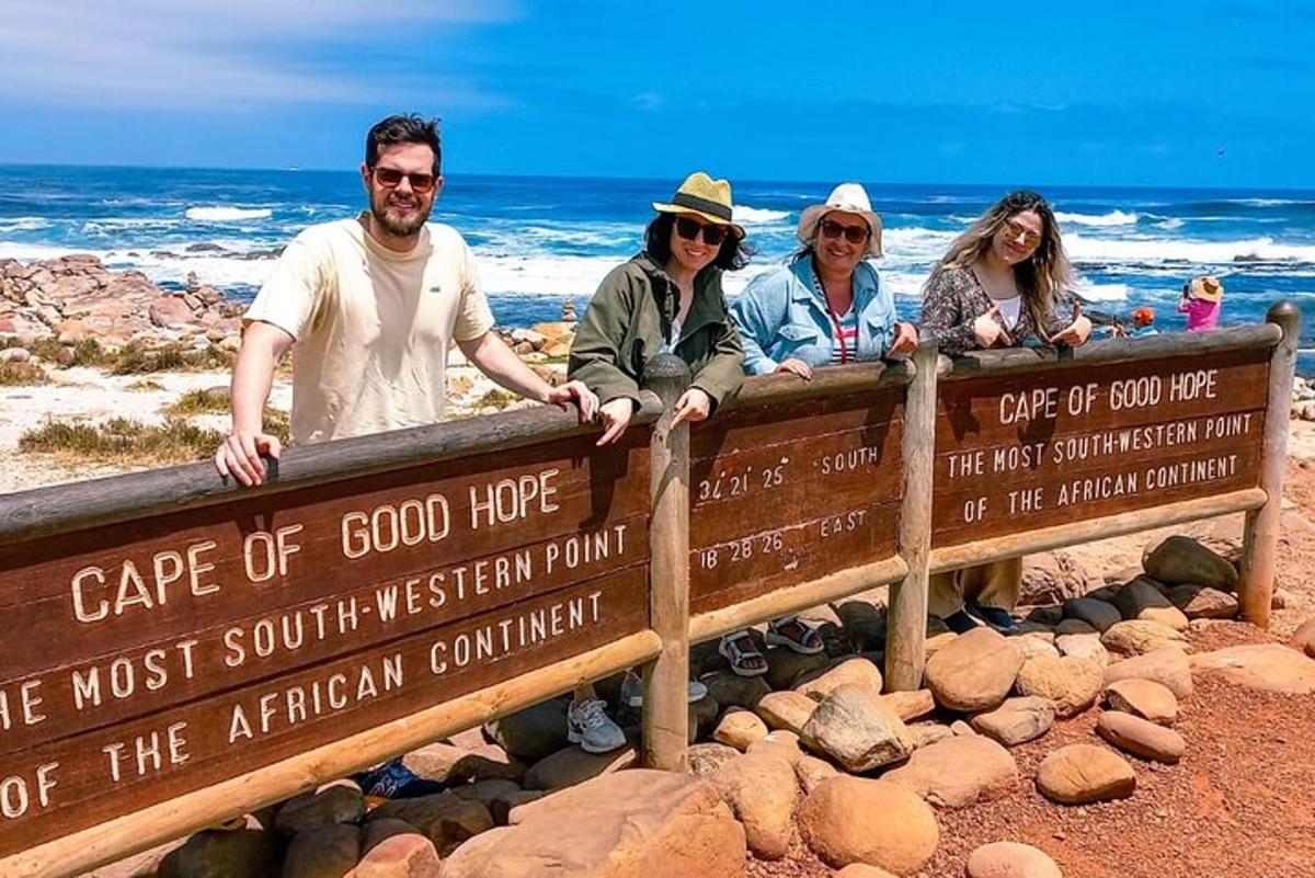 Un grupo de personas sentadas en un cartel en la playa.