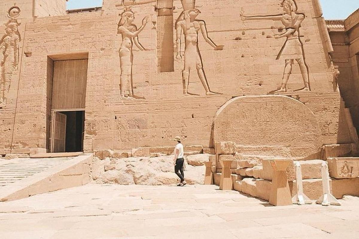 un homme debout devant un bâtiment avec des statues