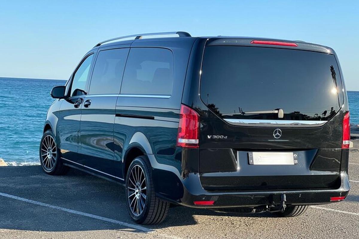 un furgone nero parcheggiato in un parcheggio vicino all'oceano