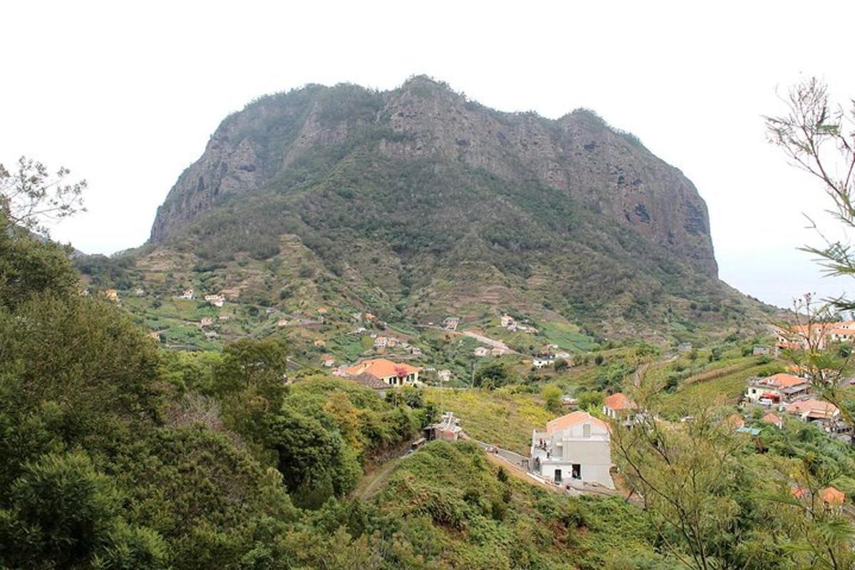 uma montanha com uma vila e casas em uma colina