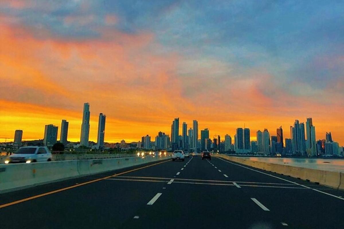 una autopista amb vistes a una ciutat a la posta de sol