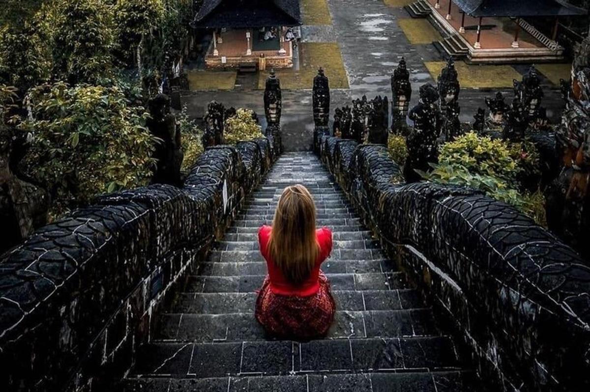 一位女士坐在楼梯上看着一栋建筑