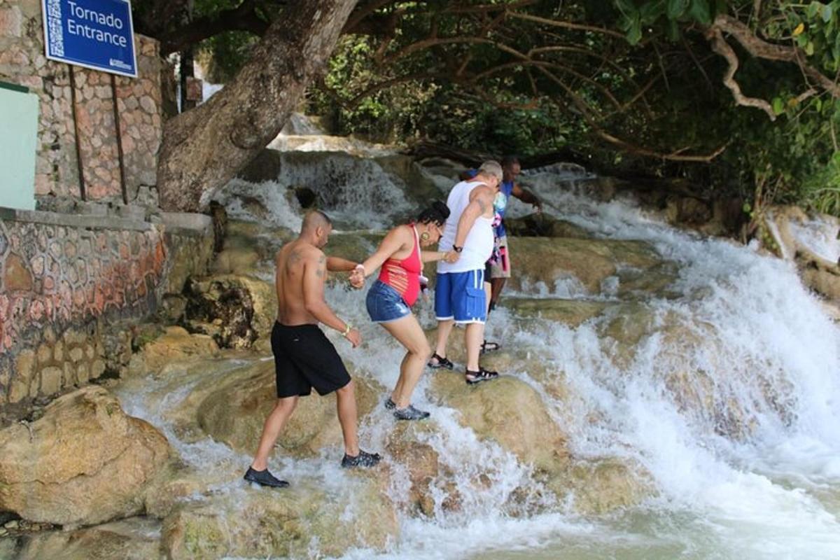 un grup de persones dempeus sobre les roques d'una cascada