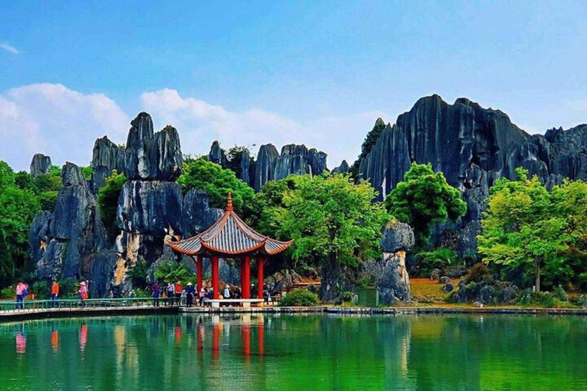 a pagoda in the middle of a lake with rock formations