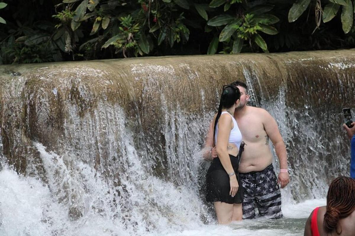 isang lalaki at isang babae na nakatayo sa harap ng isang talon