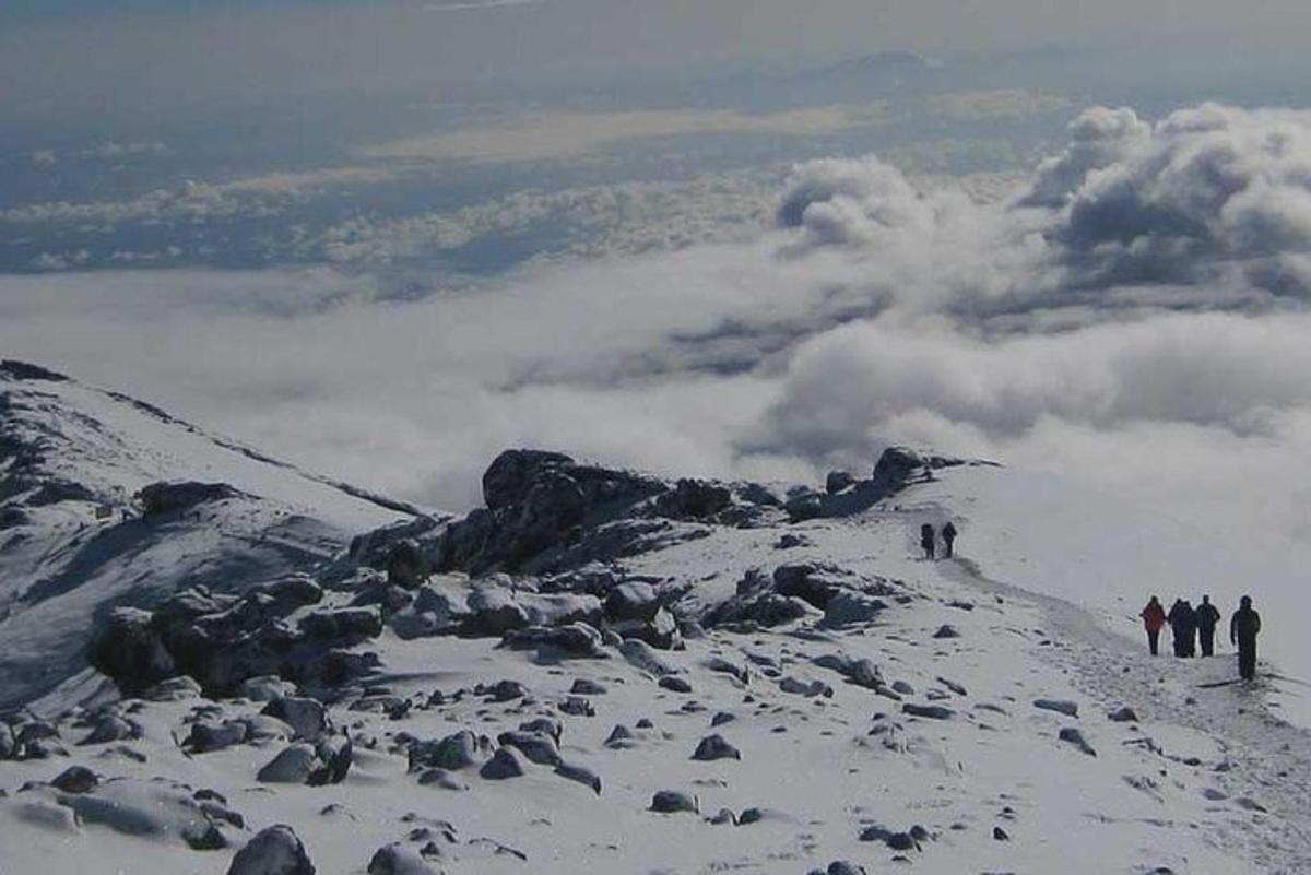 um grupo de pessoas em pé no topo de uma montanha coberta de neve