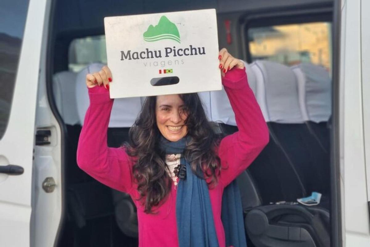 Una mujer sosteniendo un cartel frente a una camioneta