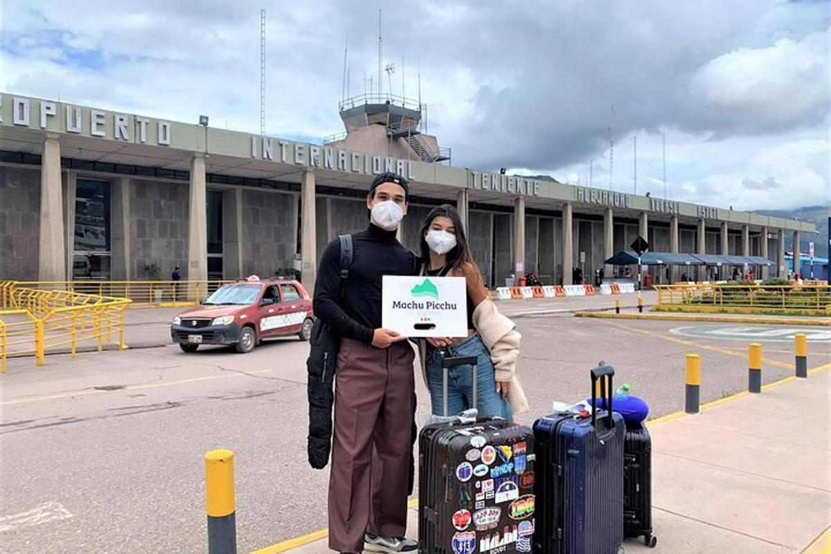 공항 앞에 마스크를 쓴 남자와 여자가 서 있다