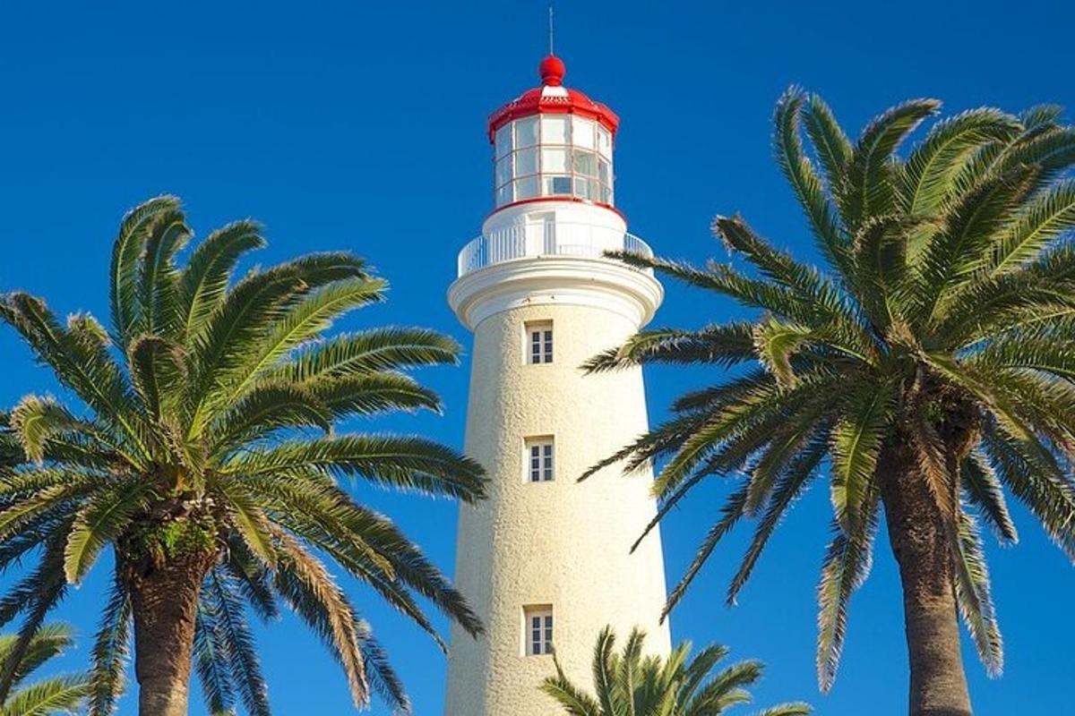 een vuurtoren met palmbomen ervoor
