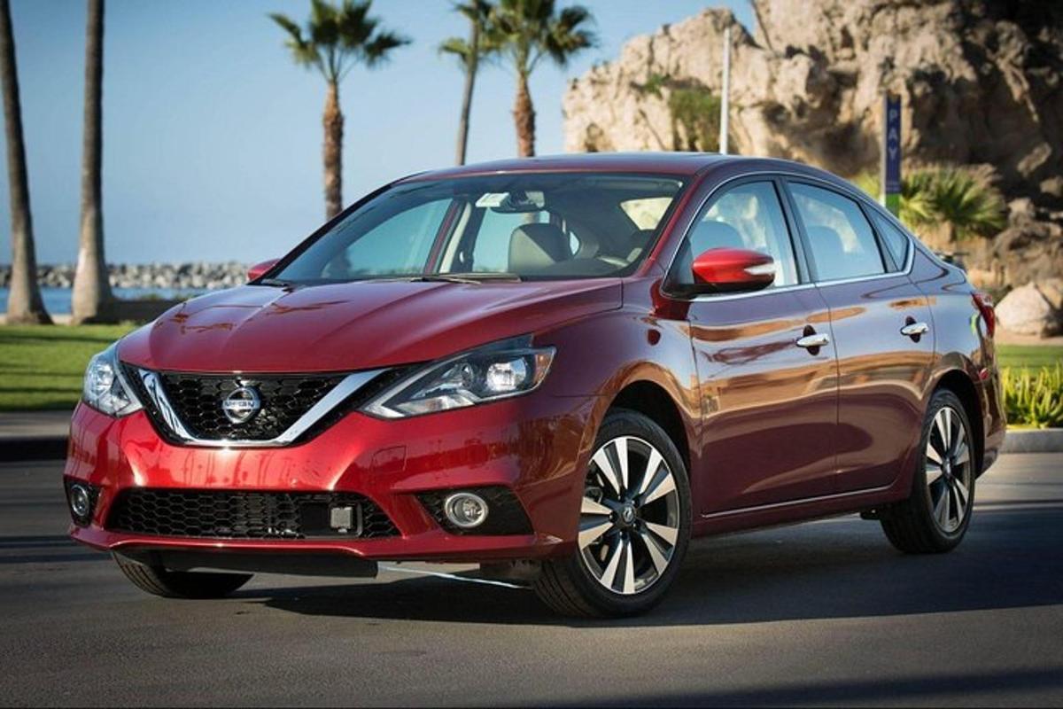 Rauður Nissan Rogue ekur niður götu