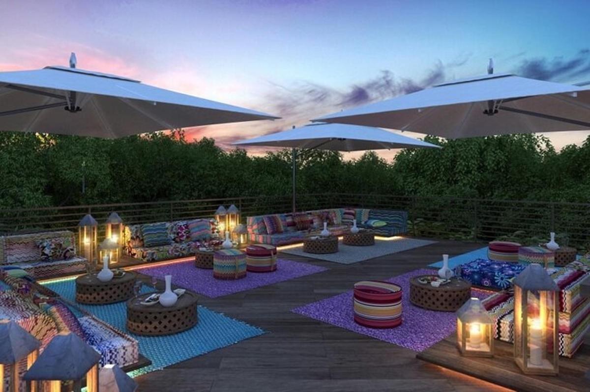 Un patio con sombrillas y una piscina con mesas y sillas.