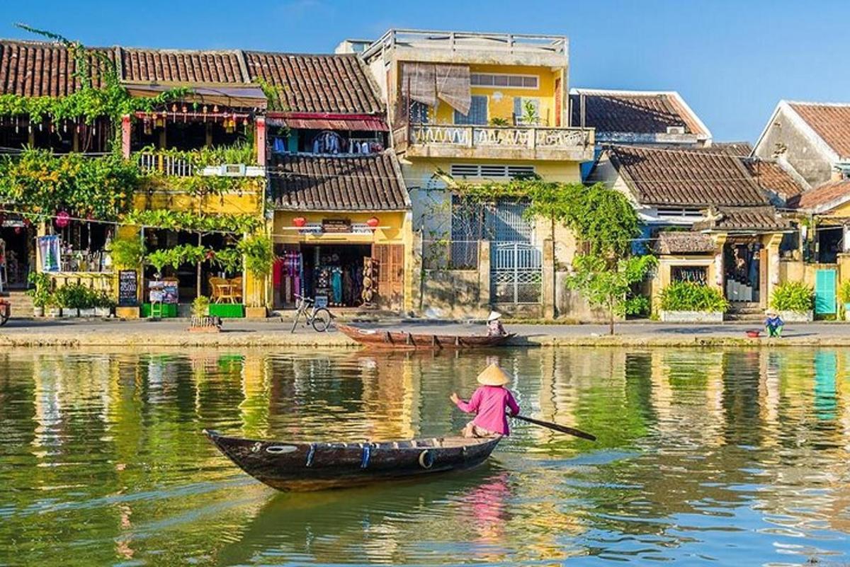 a person in a boat on a river with buildings