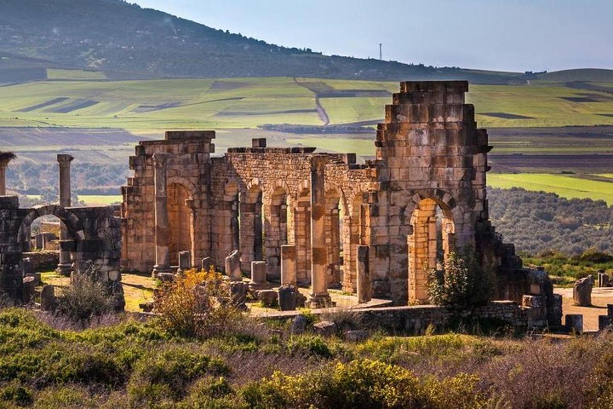 an ancient building in the middle of a field