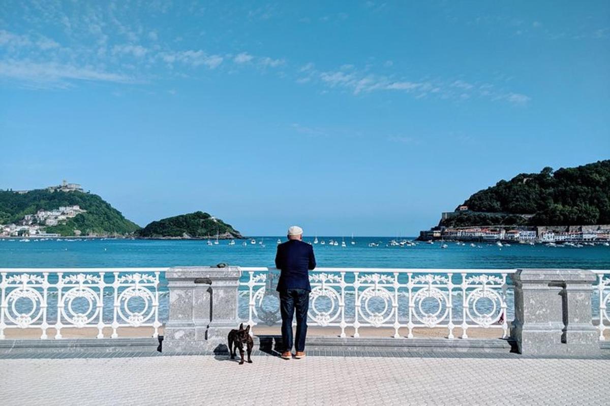 a man and a dog standing next to the ocean