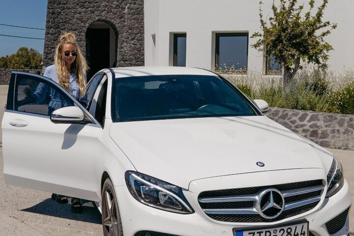 uma mulher está parada ao lado de um carro branco