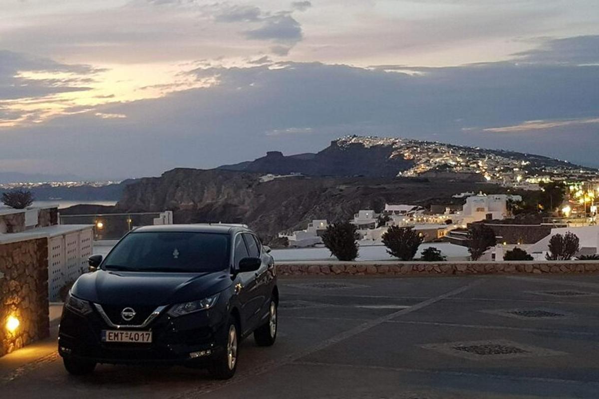 um carro preto estacionado em um estacionamento com uma montanha