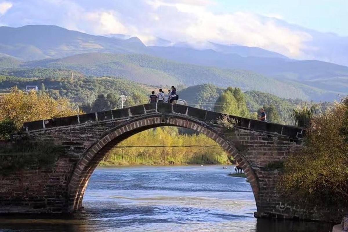 a group of people standing on a bridge over a river