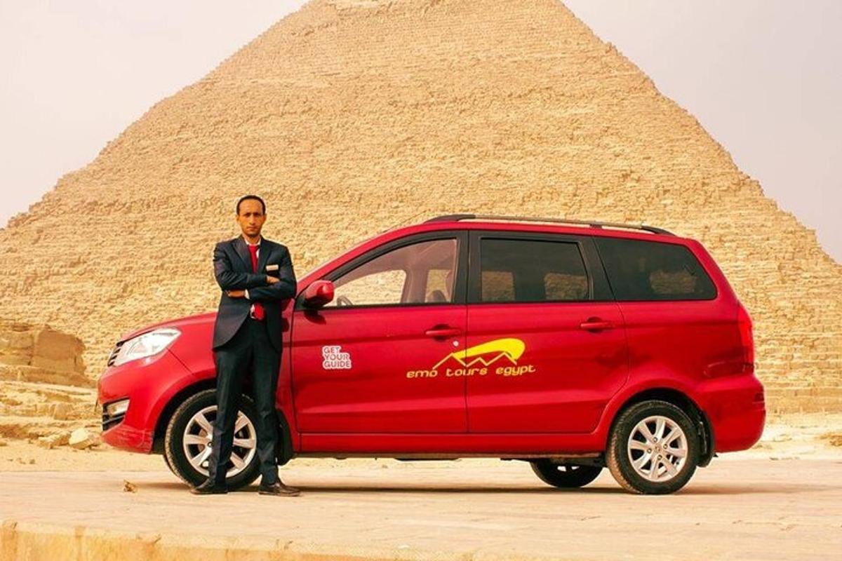 Ein Mann steht neben einem roten Lieferwagen vor einer Pyramide