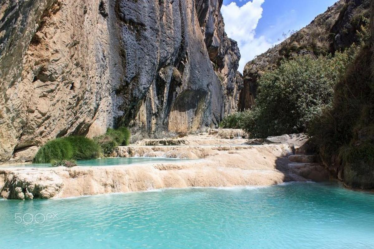 a river in the middle of a mountain with blue water