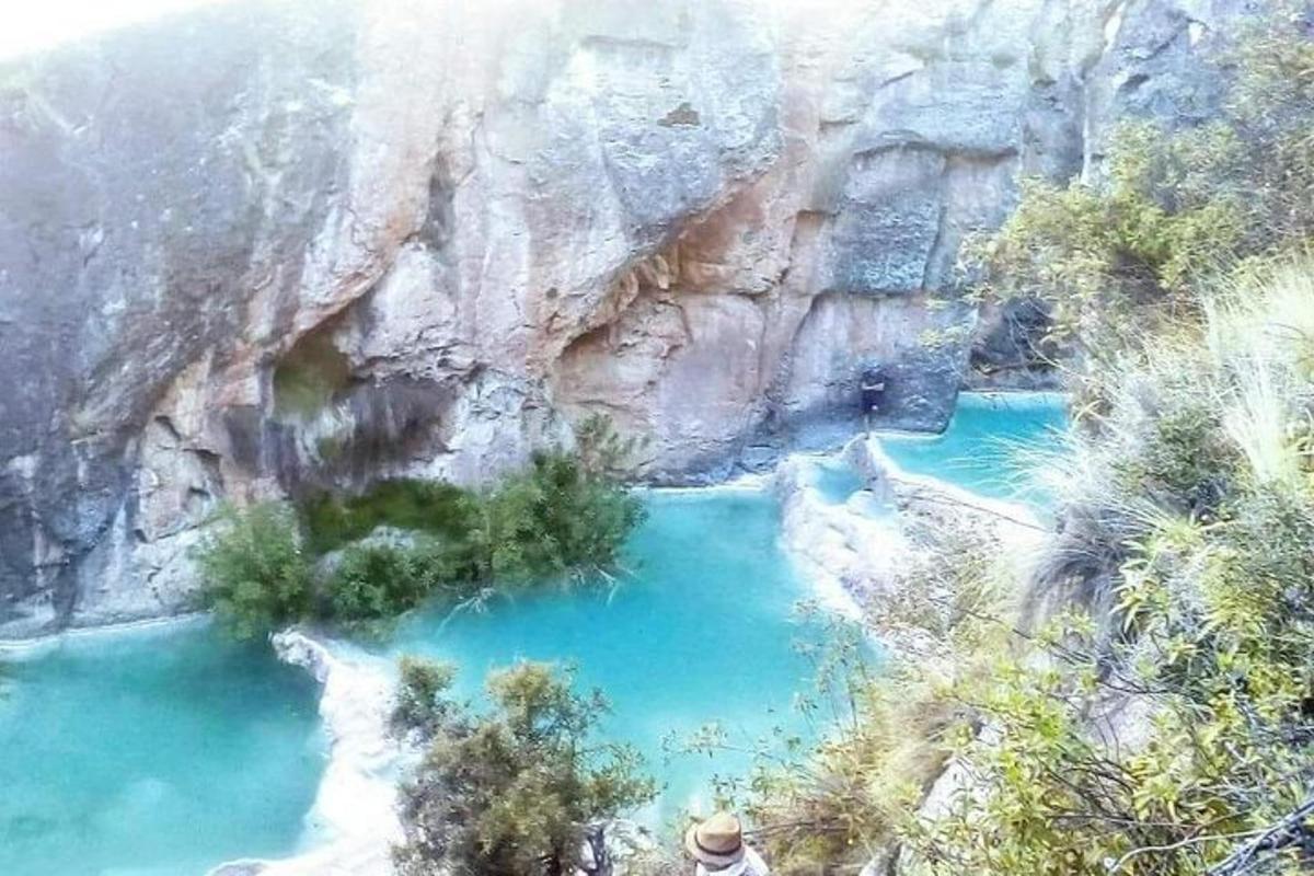 a view of a blue pool of water next to a mountain