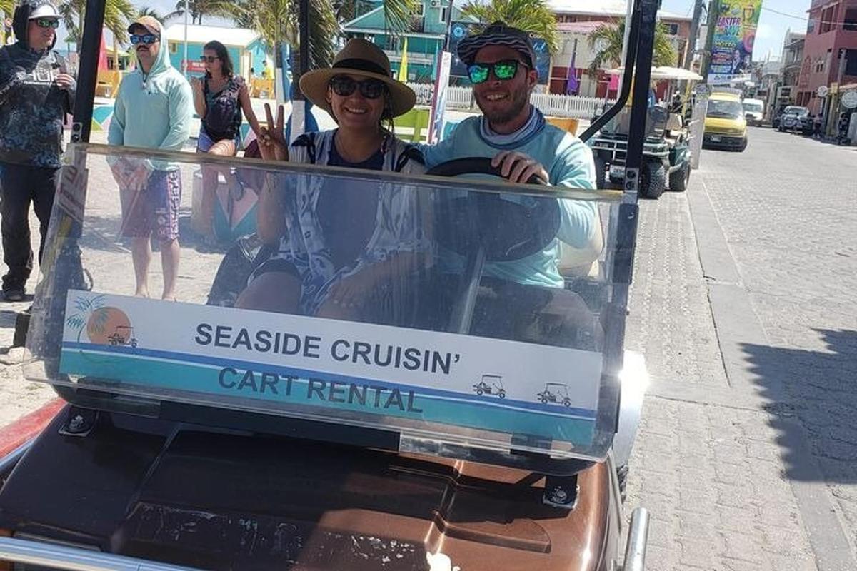 two men riding in a golf cart on a street