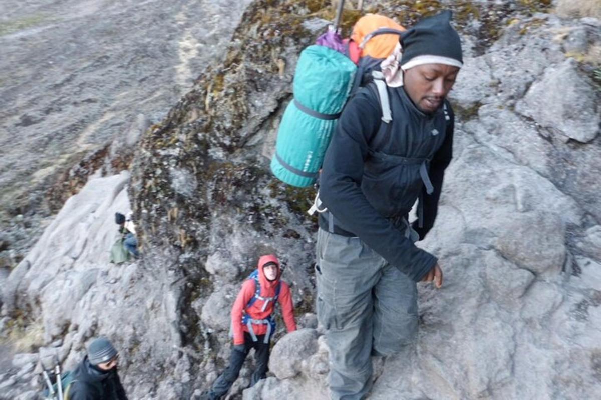 un uomo con uno zaino che sale su una montagna