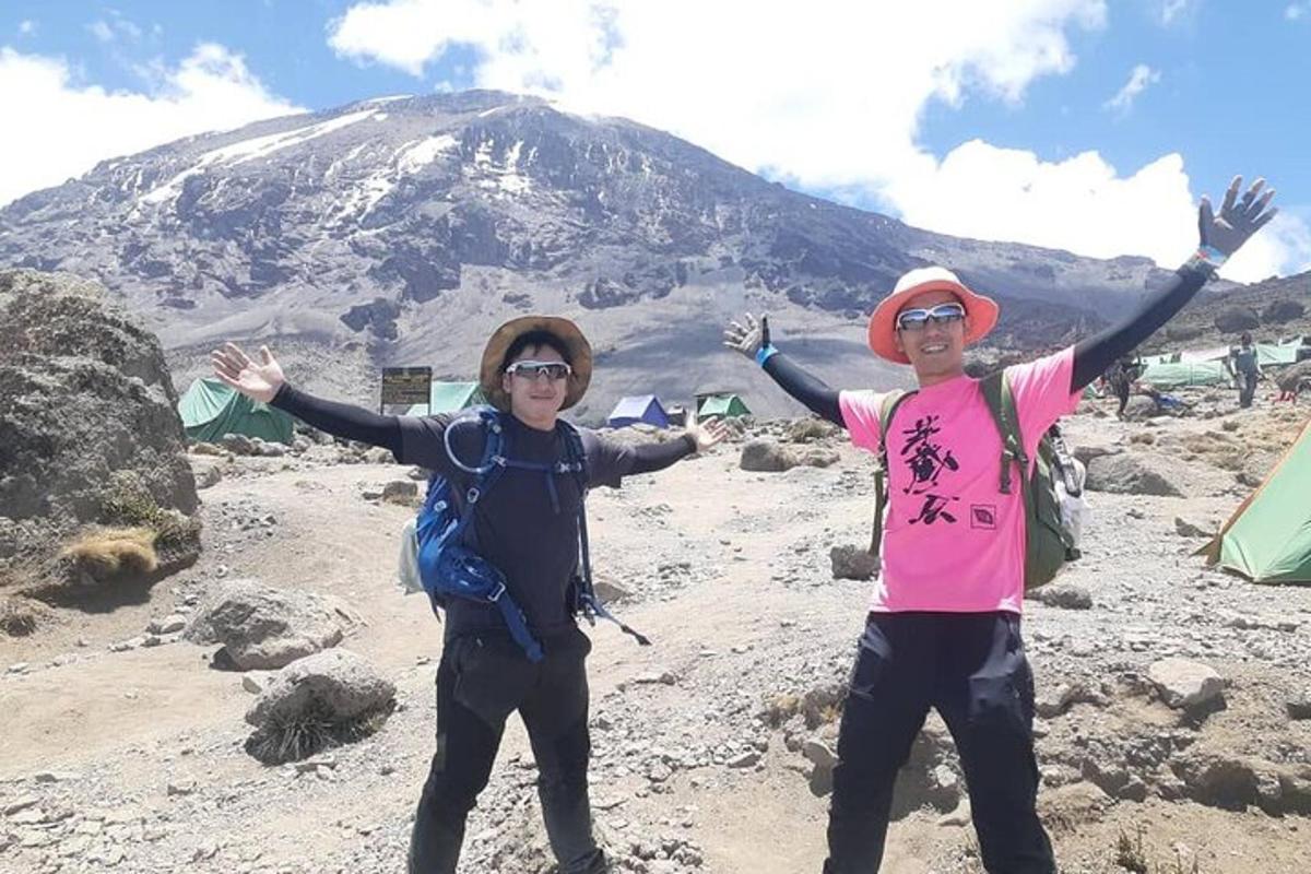 due persone in piedi sulla cima di una montagna