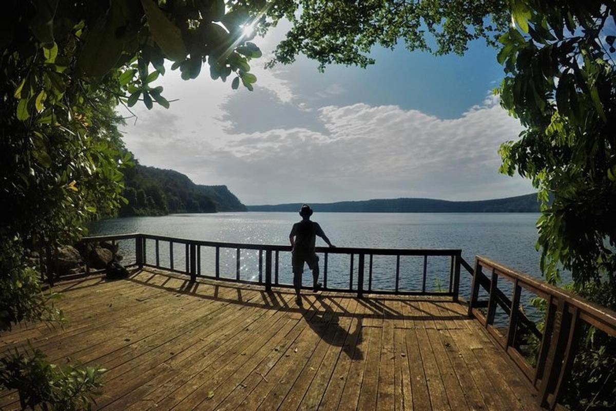 moški, ki stoji na pomolu in gleda v vodo
