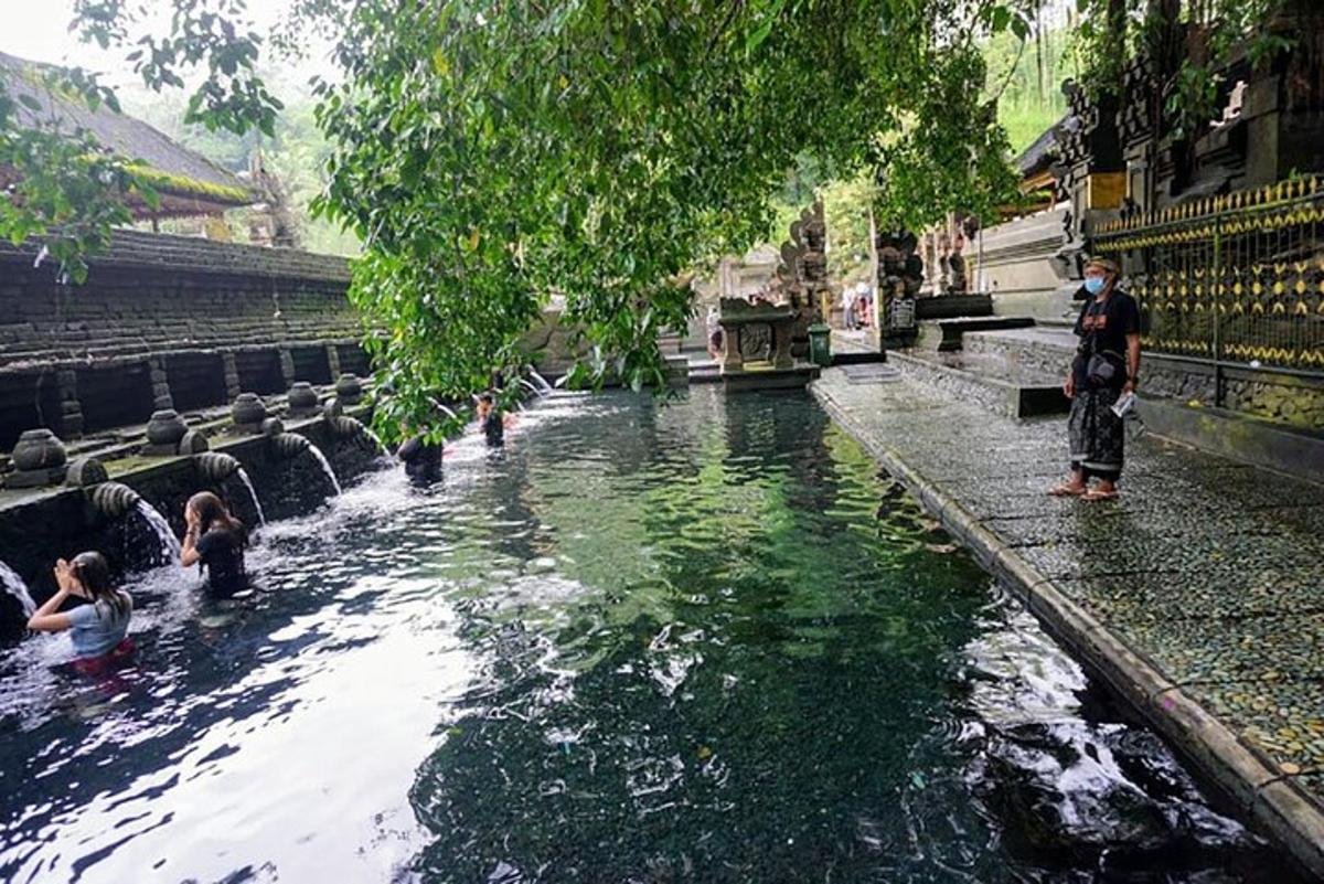 sekumpulan orang berdiri di dalam kolam air