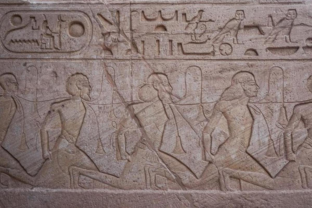un rilievo di un gruppo di persone che camminano su un muro