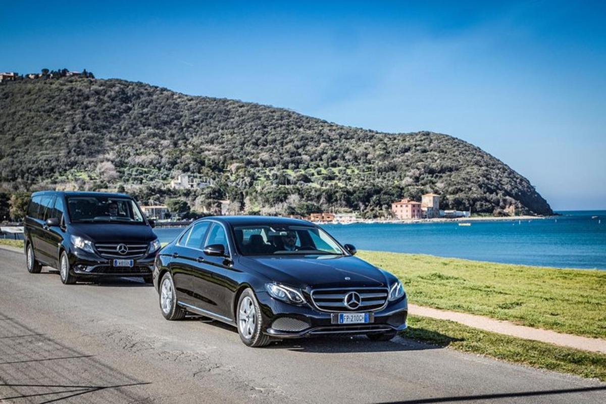 two cars parked on a road next to the ocean