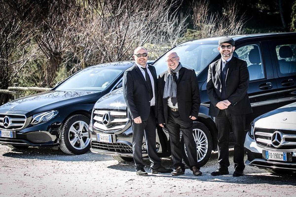 a group of four men standing in front of a car
