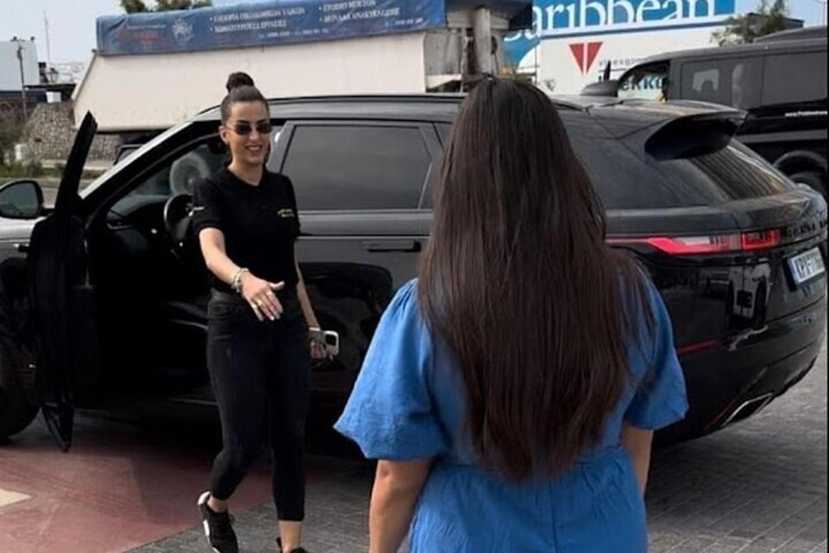 two women standing in front of a car