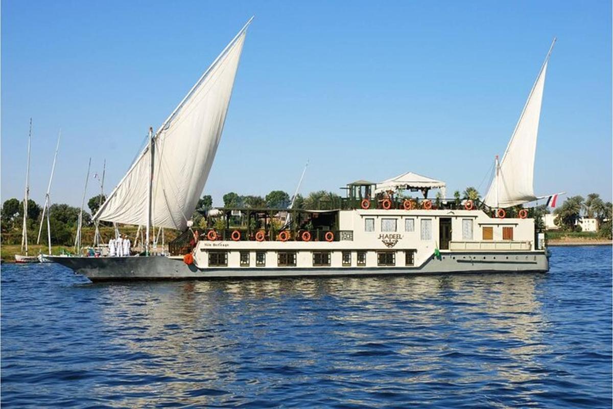 een witte boot met twee zeilen op het water