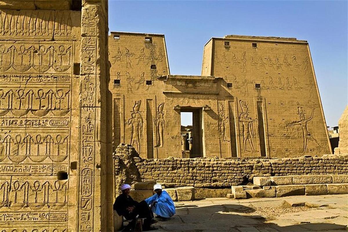 two people sitting in front of a building with carvings