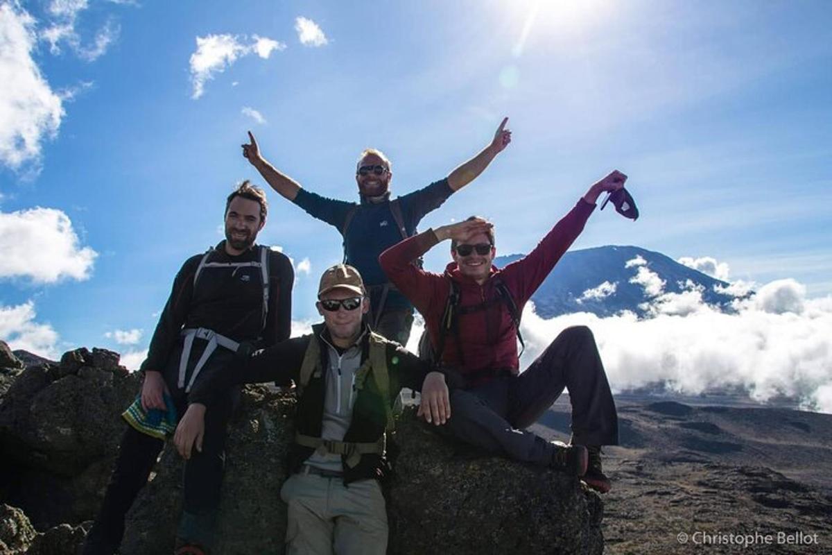 um grupo de pessoas sentadas no topo de uma montanha