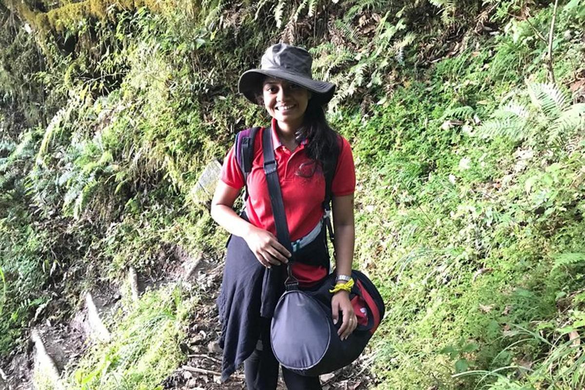 a woman in a hat standing on a trail